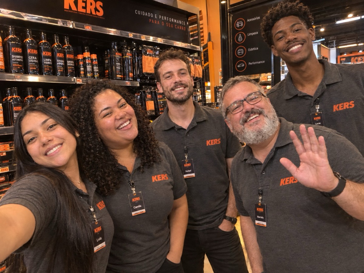 Equipe Kers de uniforme em uma loja da marca, com prateleiras de produtos Kers ao fundo